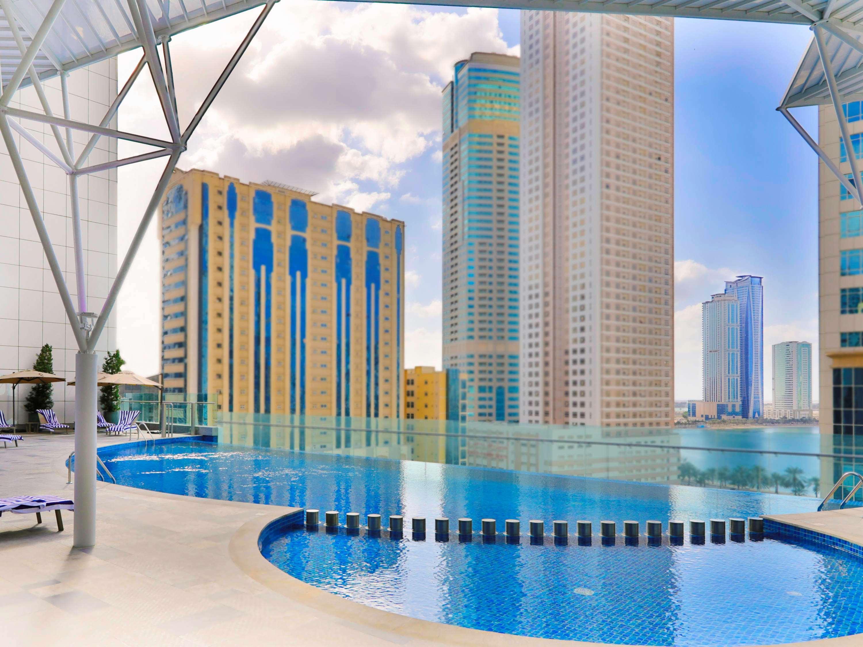Pullman Sharjah Hotell Exteriör bild The swimming pool at the complex